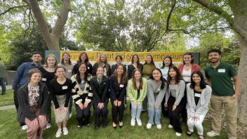 Group of students standing together in front of the Plant Science Symposium banner